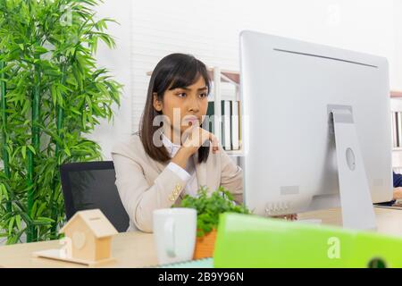 Asiatische Wirtschaftsfrauen sitzen und arbeiten mit Fleiß, Entschlossenheit im Büro Stockfoto