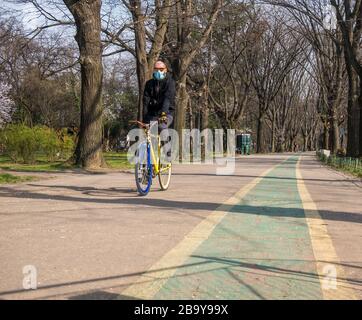 Bukarest/Rumänien - 19.03.2020: Mann rausragend ein Fahrrad mit Gesichtsmaske. Schutz vor Coronavirus-Pandemie. Stockfoto