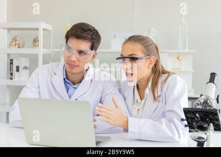 Das Konzept von Gesundheitsforschern, Forschern, die in biologischen Wissenschaftslabors arbeiten, jungen Forschungswissenschaftlern und männlichen Vorgesetzten Stockfoto