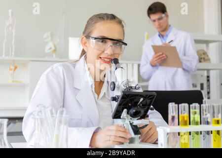 Das Konzept einer neuen Generation wissenschaftlicher Forscher, die in einem Labor ein Mikroskop durchschauen, forschen junge Wissenschaftler. Stockfoto
