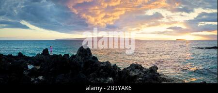 Frau, die bei Sonnenuntergang ein Foto vom Meer gemacht hat. Stockfoto
