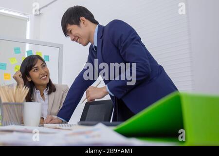 Asiatische Geschäftsleute und Männer sitzen im Büro Stockfoto