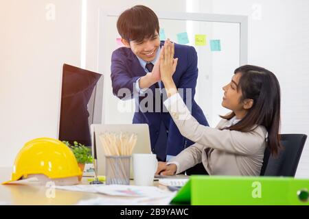 Die Mitarbeiter von asiatischen Männern und Frauen arbeiten gut zusammen. Stockfoto