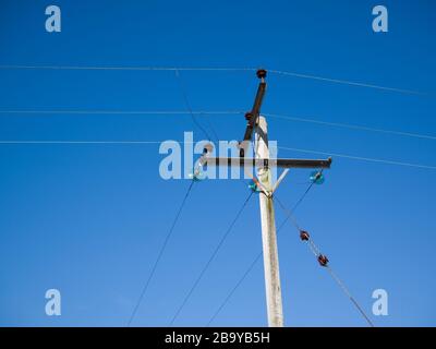 Über Holzmast montierte 11kv Hochspannungs-Dreiphasen-Stromverteilerkabel. Stockfoto