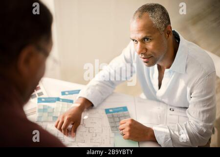 Vater mit seinem erwachsenen Sohn Beratung zu Hause Renovierungen. Stockfoto