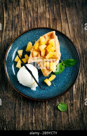 Belgische Waffeln mit karamellisiertem Apfel, Eis und Honig Stockfoto