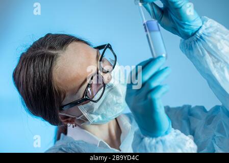 Eine Frau, die Ärztin, die Apothekerin ist, hält eine Testflasche mit einem Impfstoff gegen das im Labor entwickelte Virus. Konzeptsuche nach Technologien für Stockfoto