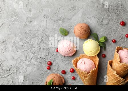 Eis mit Waffeln und Beeren auf grauem Hintergrund, Draufsicht Stockfoto