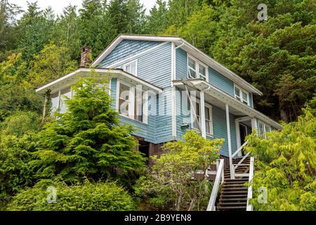 Gehäuse in Telegraph Cove mit Holzchalet-Architektur auf Stelzen im Wald, Vancouver Island, British Columbia, Kanada. Stockfoto