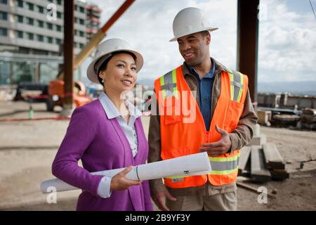 Zwei Kollegen diskutieren ein Projekt auf einer Baustelle. Stockfoto