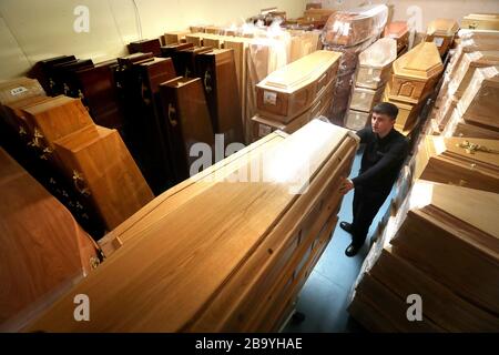 Declan Harley von Anderson Maguire Funeral Directors überprüft die leeren Särge im Lagerraum in ihren Büros in Glasgow. Die Leiter der Beerdigungsbehörde in Schottlands größter Stadt stehen vor einem Rückstau und kurz vor dem Auslaufen des Leichenraums, sagte der Chef eines Familienunternehmens. Beerdigungen können erst durchgeführt werden, wenn Todesfälle registriert wurden und persönliche Termine in den Registrierungsstellen nach den Anweisungen von Coronavirus nicht verfügbar sind. Stockfoto