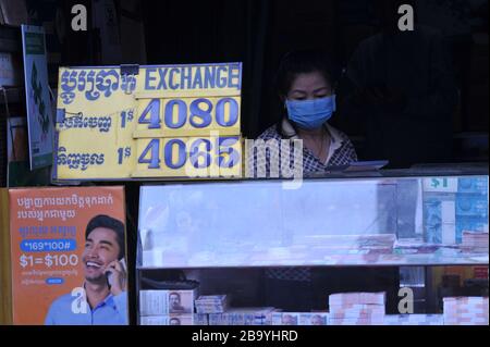 Eine kambodische Frau, die während der Coronavirus Pandemie eine Gesichtsmaske an einem Geldwechselstand trägt. Kandal Market, Phnom Penh, Kambodscha. © Kraig Lieb Stockfoto