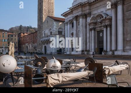 Leere Tische vor einer Bar am Paul VI Platz in Brescia (Lombardei) als Folge der von der italienischen Regierung verhängten Ansteckungskontrollmaßnahmen. Stockfoto