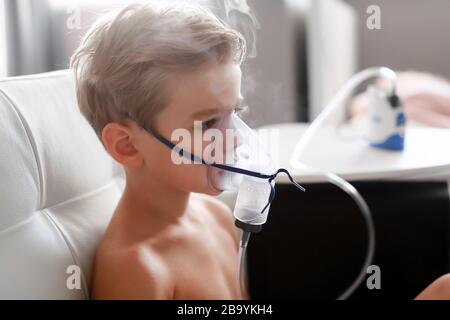 Ein Junge mit Atemschutzmasken behandelt. Rauchen Sie zu Hause Stockfoto