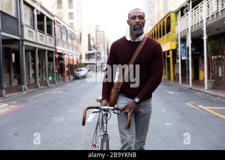 Afroamerikanischer Mann mit dem Fahrrad in der Straße der Stadt Stockfoto