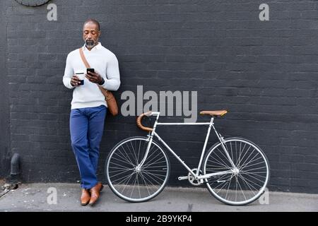 Afroamerikanischer Mann und sein Fahrrad auf der Straße Stockfoto