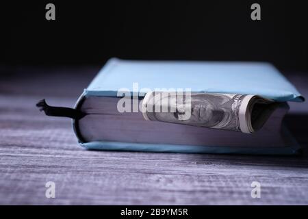 Geld, das in einem Buch gespart wird, spart Geld für das Bildungskonzept Stockfoto