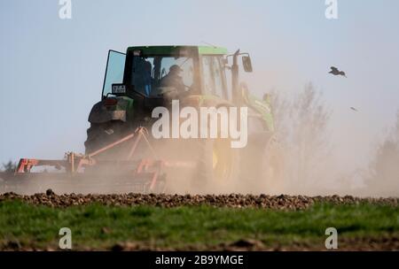 25. März 2020, Hessen, Frankfurt am Main: Staub tritt auf, während ein Bauer ein Feld im Kreis Bergen bearbeitet. Im Süden Hessens regnete es seit einigen Tagen nicht mehr deutlich. Foto: Frank Rumpenhorst / dpa Stockfoto