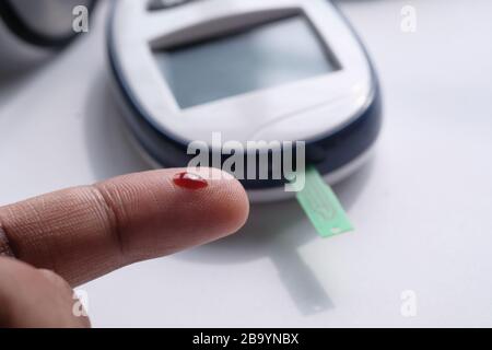 Männer Finger mit Blut messen Blutzuckerdiabetes, Stockfoto