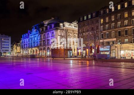 Nachtansicht des Jaude Platzes (Place de Jaude), Clermont Ferrand in Frankreich, beleuchtet durch violettes Licht, umgeben von traditionellen französischen Gebäuden und Geschäften Stockfoto