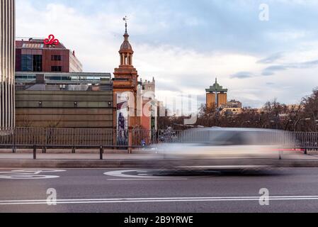 Madrid, Spanien - 8. März 2020: Stadtbild der Paseo de la Castellana Avenue mit Colon-Türmen, verschwommenes bewegtes Fahrzeug im Vordergrund Stockfoto