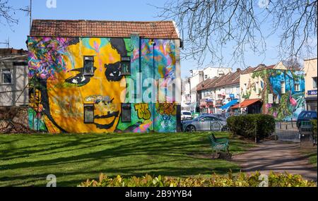 Mina Road Park in Bristol UK mit Wandbild einer Frau, die auf einem angrenzenden Haus gemalt ist Stockfoto