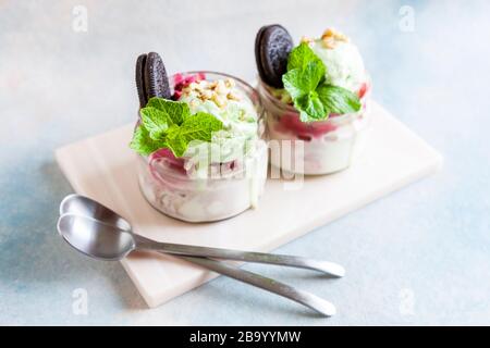 Zwei leckere, hausgemachte bunte Popplisseis mit Minze- und Schokoladeplätzchen, die in einem Glasgefäß liegen Stockfoto