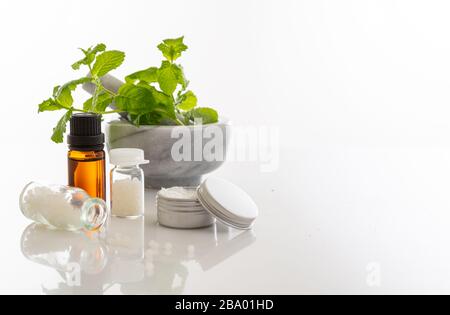Alternative Pflanzenheilkunde. Homöopathische Globules, frisches Minzkraut isoliert vor weißem Hintergrund. Aromatherapie, Homöopathie Naturprodukte Stockfoto