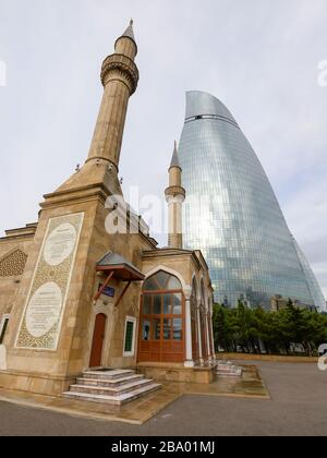 Die Moschee der Märtyrer vor dem modernen Wolkenkratzer kennt man als Flame Towers in Baku, Aserbaidschan. Auch als türkische Moschee bekannt. Stockfoto