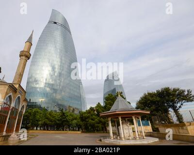 Moschee der Märtyrer vor dem modernen Wolkenkratzer kennen die Flame Towers in Baku, Aserbaidschan an einem bewölkten Tag. Auch als türkische Moschee bekannt. Stockfoto