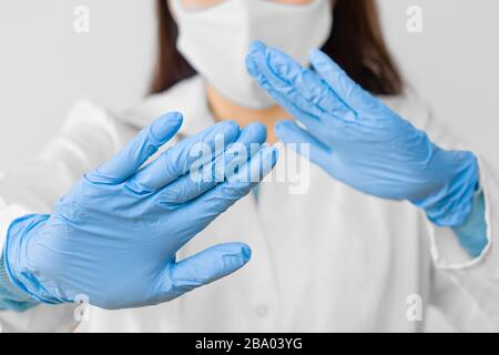 Stoppen Sie SARS-COV, SARSCoV, Virus 2020, MERS-COV, chinese Virus COVID-19. Close-Womans Hände in blauen medizinischen Handschuhen zeigen EIN STOPPZEICHEN für Krankheit. Arzt Stockfoto