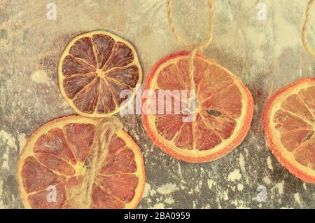 Getrocknete Früchte Mandarinen, Orangen und Limonen. Getrockneter Kalk, Orangen auf einem Metallofen. Natürliche Einrichtung auf Metallhintergrund. Stockfoto