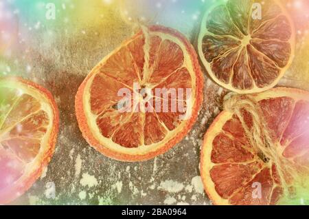 Getrocknete Früchte Mandarinen, Orangen und Limonen. Getrockneter Kalk, Orangen auf einem Metallofen. Natürliche Einrichtung auf Metallhintergrund. Stockfoto