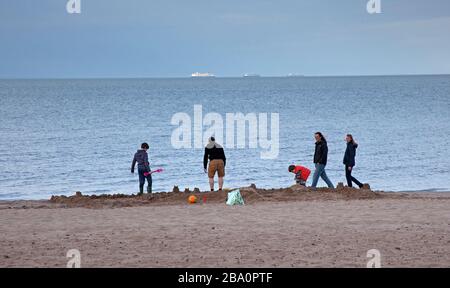Portobello, Edinburgh, Schottland, Großbritannien. März 2020. Der Nachmittag am Portobello Beach ist extrem ruhig, da sich dieser Vater und seine Söhne durch den Bau einer großen Sandstruktur auskennen. Temperatur von 13 Grad Celsius. Stockfoto