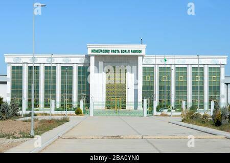 Fassade der Koneurgench Cotton Spinning Factory in Dashoguz, Turkmenistan. Mit weißem Marmor gebaut und mit Gold verziert. Turkmenische Textilindustrie. Stockfoto