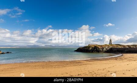 Der Leuchtturm von TWR Bach auf der Insel Llanddwyn mit Snowdonia im Hintergrund, Anglesey Stockfoto