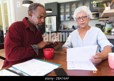 Älteres afroamerikanisches Paar, das ihre Verwaltungsarbeiten macht Stockfoto