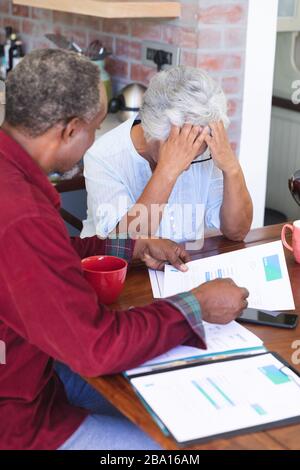 Älteres afroamerikanisches Paar, das ihre Verwaltungsarbeiten macht Stockfoto