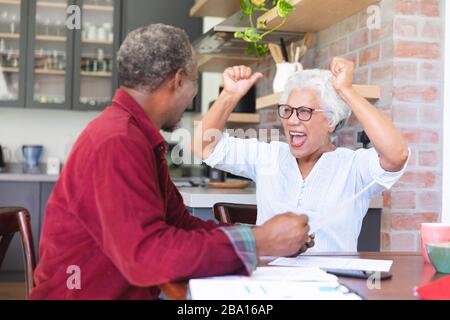 Älteres afroamerikanisches Paar, das ihre Verwaltungsarbeiten macht Stockfoto