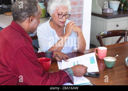 Älteres afroamerikanisches Paar, das ihre Verwaltungsarbeiten macht Stockfoto