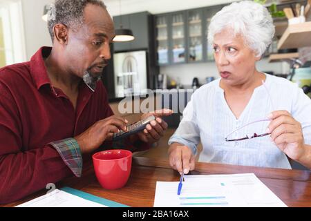 Älteres afroamerikanisches Paar, das ihre Verwaltungsarbeiten macht Stockfoto