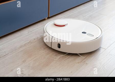 Roboter-Staubsauger auf Laminatboden mit intelligenter Reinigungstechnologie Stockfoto