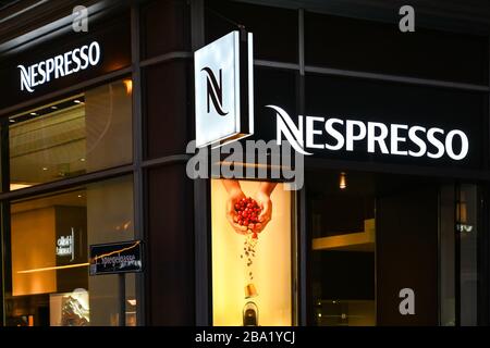 WIEN, ÖSTERREICH - NOVEMBER 2019: Leuchtschild außen an einer Nespresso-Filiale nachts in der Wiener Innenstadt Stockfoto