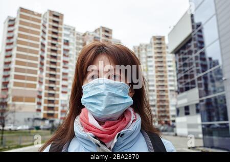 Frau, die hygienische Maske trägt, um das Coronavirus zu verhindern. Menschen in Masken den Ausbruch des neuartigen Corona-Virus (2019-nCoV) in Europa. Konzept von Coronavir Stockfoto