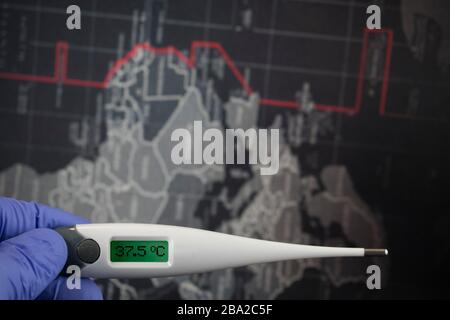 Coronavirus COVID-19. Konzept, das den Virus des chinesischen Wuhan darstellt. Weltkarte im Hintergrund. Die Arzthand mit Handschuhen hält digitales Thermome Stockfoto