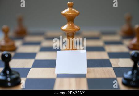 Konzept Schachfiguren drücken soziale Distanzierung mit leerem weißen Brett vor dem Mittelstück aus. Stockfoto