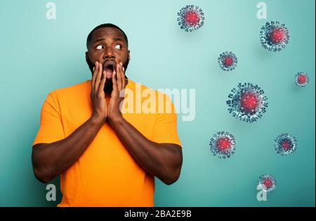 Ängstlicher Ausdruck eines Jungen, der Angst hat, den Virus zu fangen. Hintergrund Zyan Stockfoto