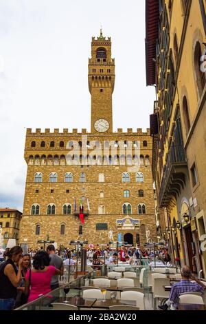 Blick auf den mit Touristen überfüllten Platz Piazza della Signoria-L-förmige vor dem Palazzo Vecchio in Florenz, Toskana, Italien. Am heißen Sommertag Stockfoto