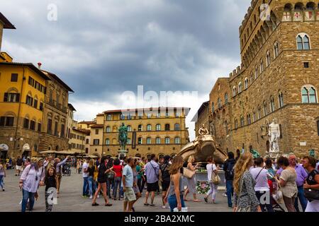 Blick auf den mit Touristen überfüllten Platz Piazza della Signoria-L-förmige vor dem Palazzo Vecchio in Florenz, Toskana, Italien. Am heißen Sommertag Stockfoto