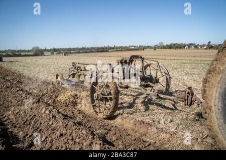Alte und alte fordson Tractorr, die mit einem Pflug auf den Feldern arbeiten und zeigen, wie die Landwirtschaft vor vielen Jahren erfolgte. Stockfoto